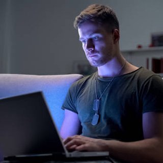 image from iStock of student wearing dog tags taking a remote course via laptop